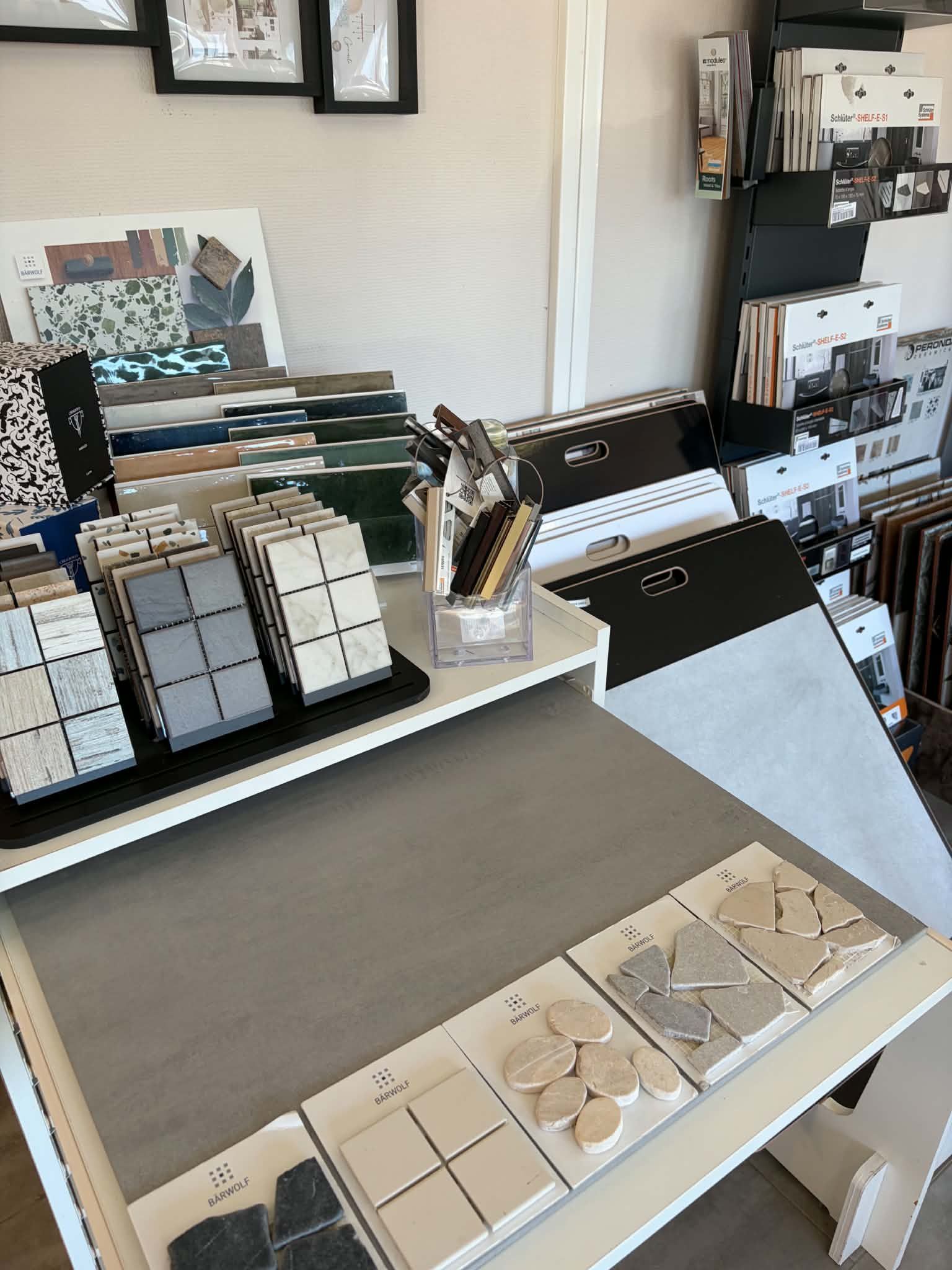 Présentoir de bureau avec échantillons, échantillons de matériaux et carnets soigneusement rangés.