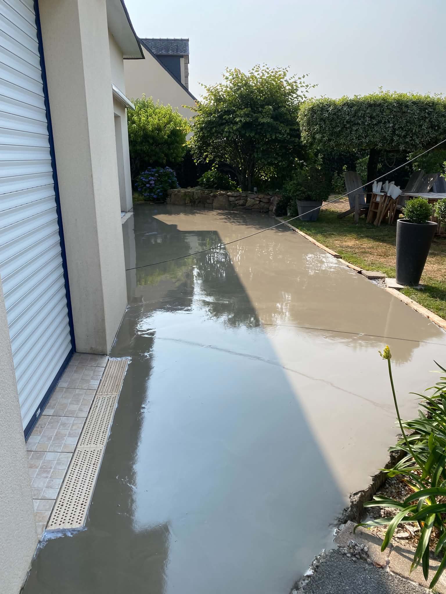 Allée recouverte d'eau longeant une maison.