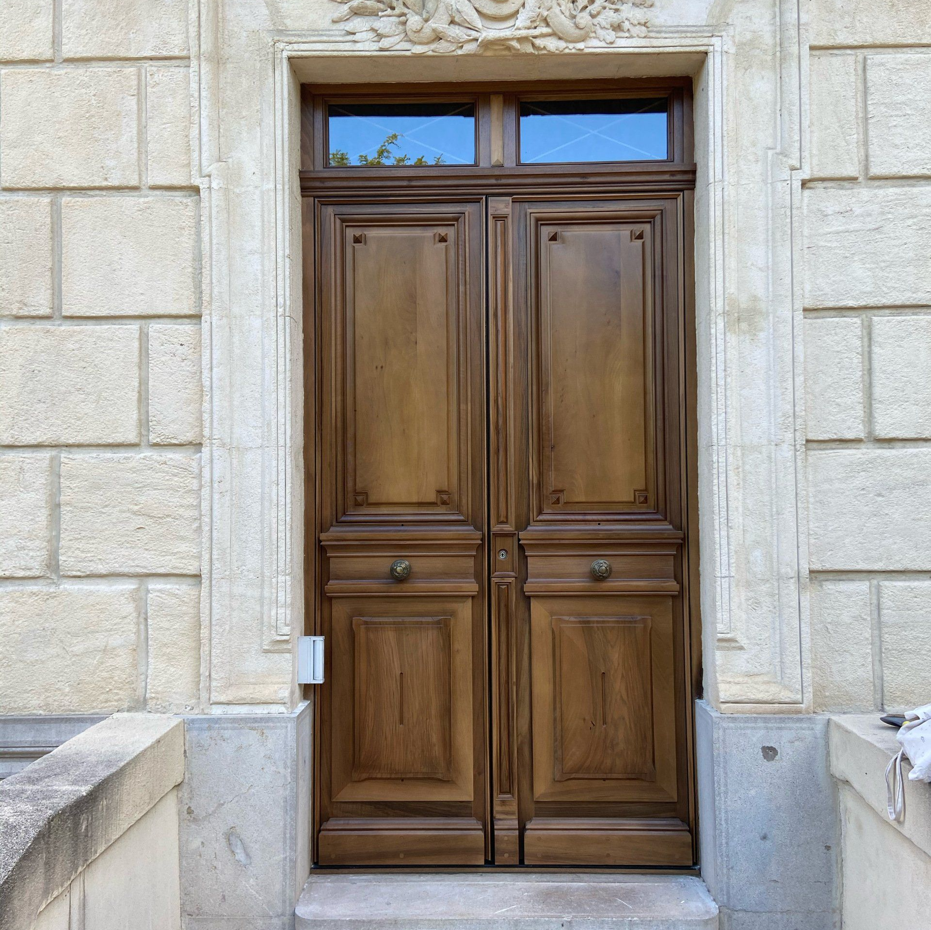Porte d'entrée en bois avec encadrement en pierre, installation par Arole, menuiserie à Nîmes