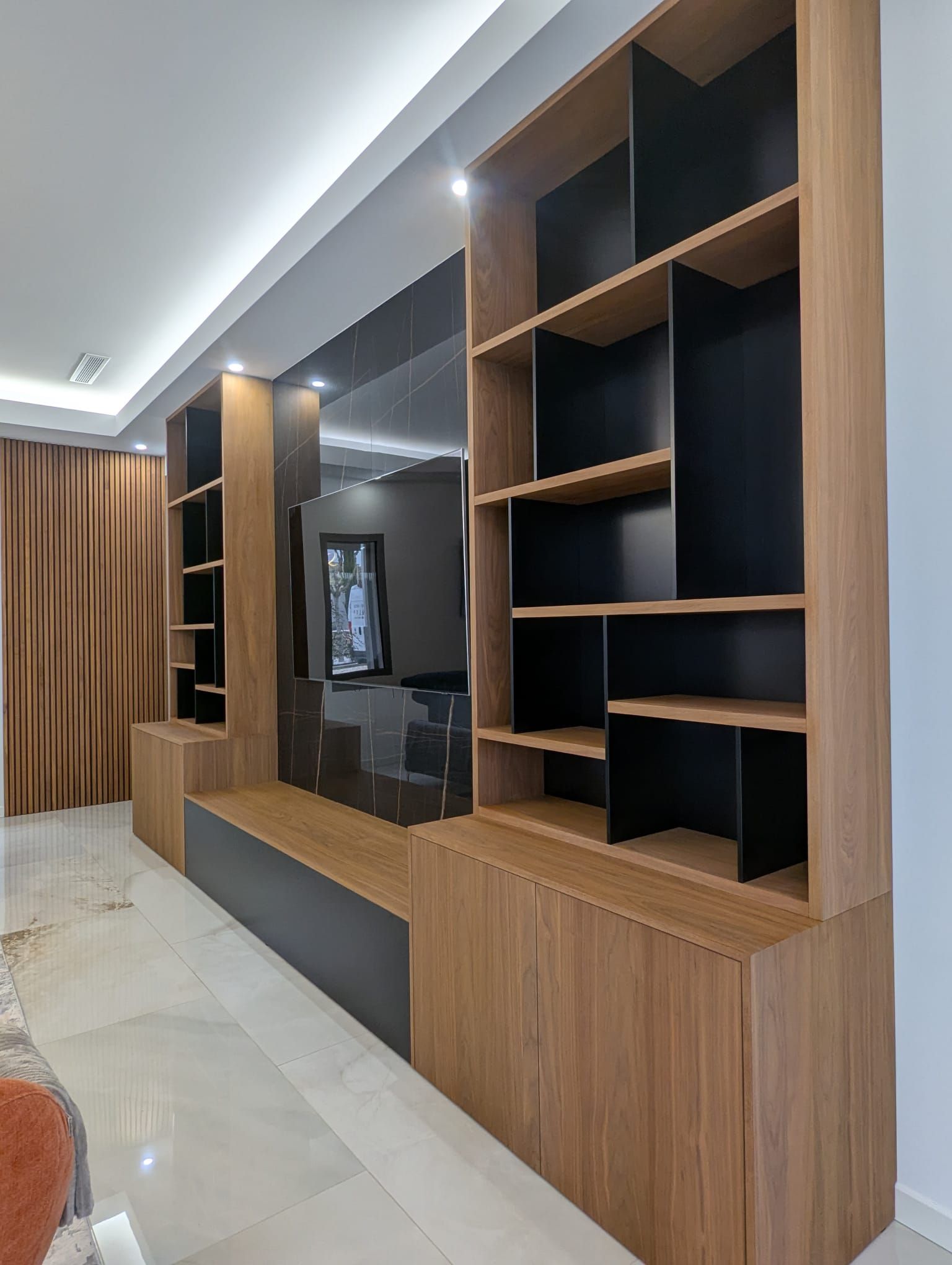 Meuble mural moderne pour salon avec étagères en bois, placards foncés et console TV intégrée