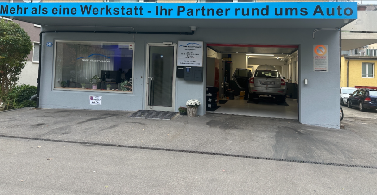Ein Gebäude mit blauem Vordach, zwei Autos davor geparkt.