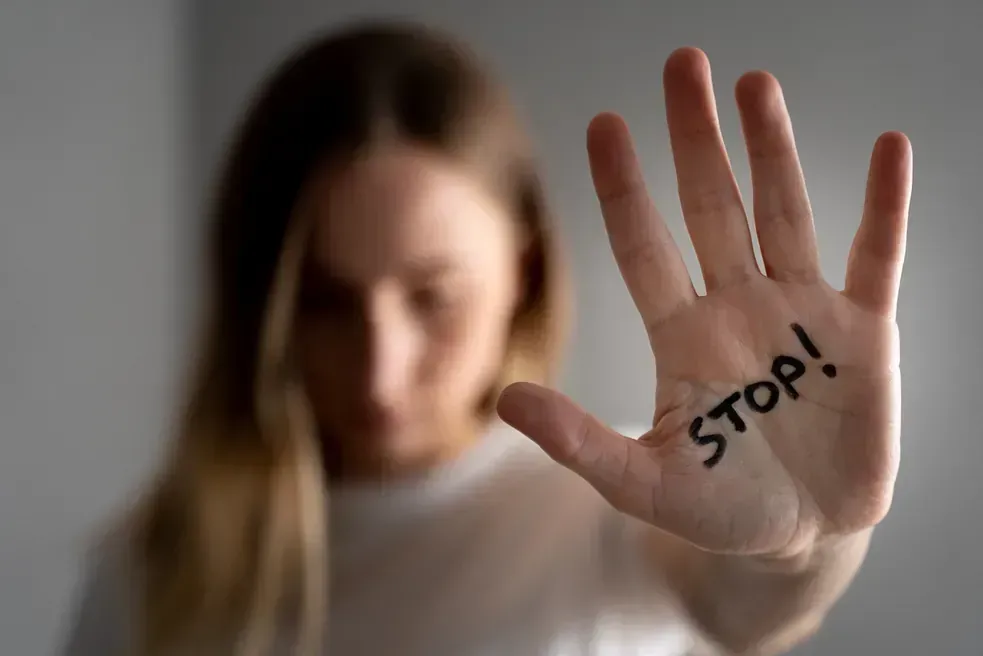 Una mujer levanta su mano con la palabra 