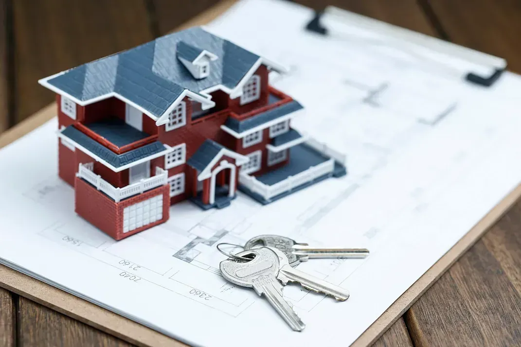 Una casa modelo y las llaves están en un portapapeles.
