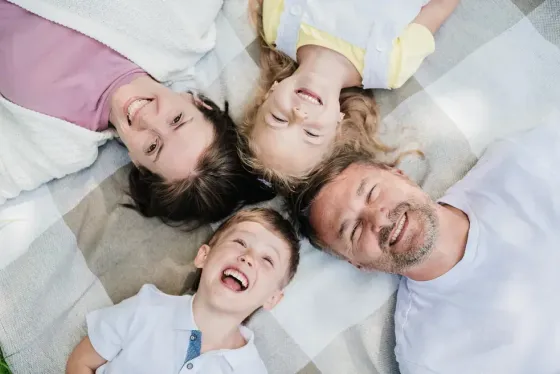 Una familia está acostada sobre una manta en un círculo.