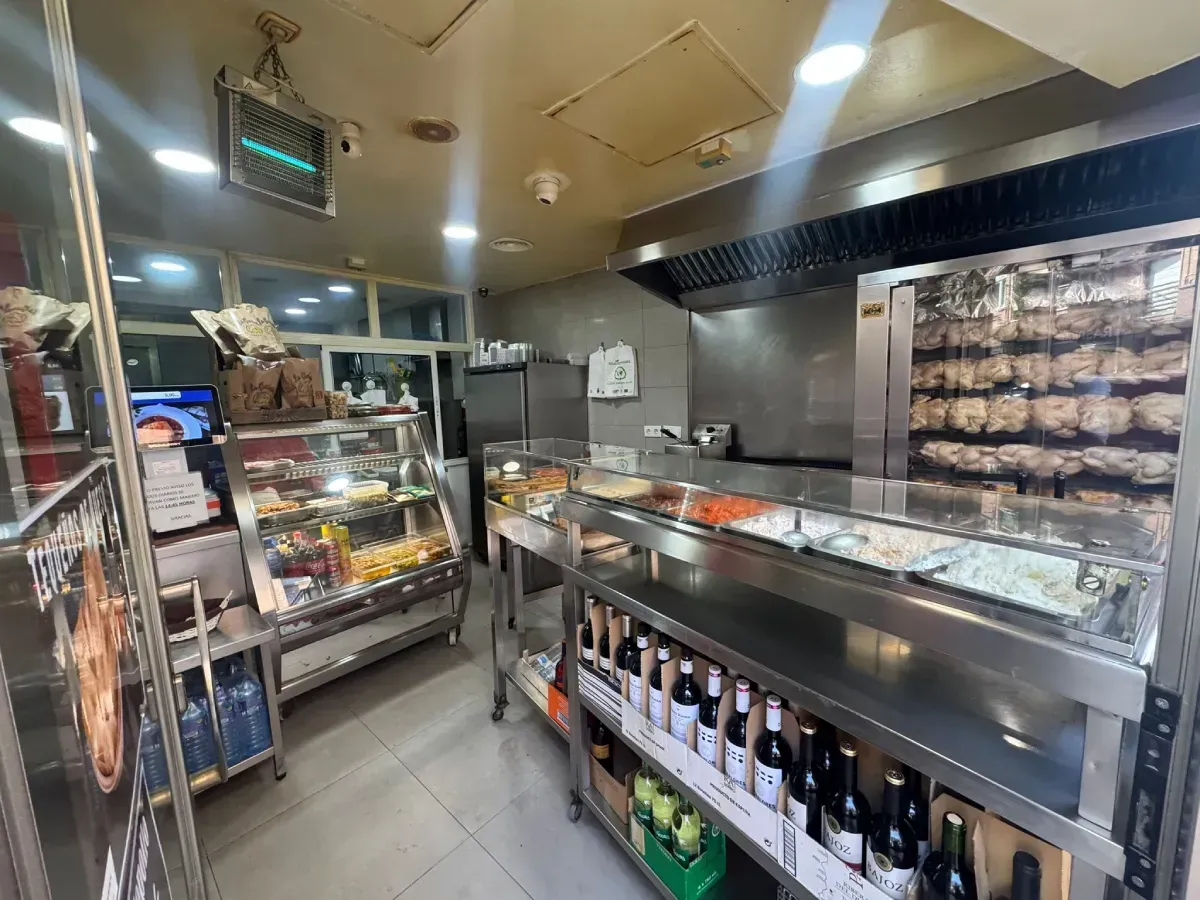 Pollo asado con patatas fritas en un plato blanco.