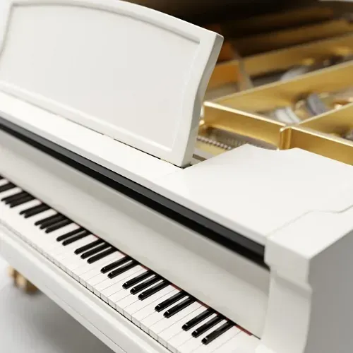 Un piano de cola blanco con la tapa abierta.