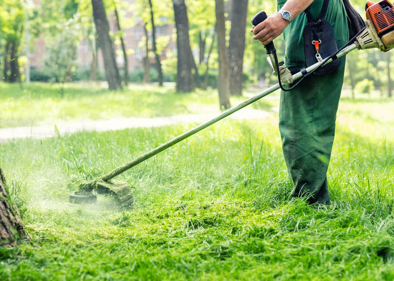 Personne réalisant le débroussaillage d'un espace public