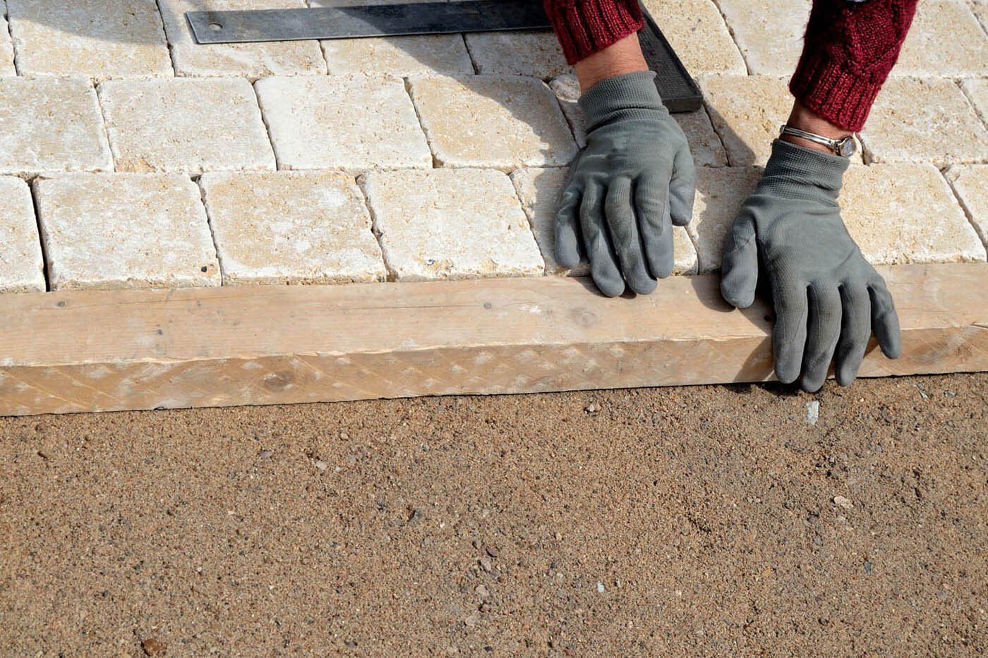 Spécialiste réalisant le pavage avec des pierres beiges