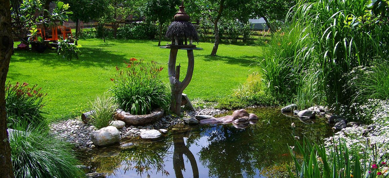 Décoration en bois à côté d'un bassin dans un grand jardin