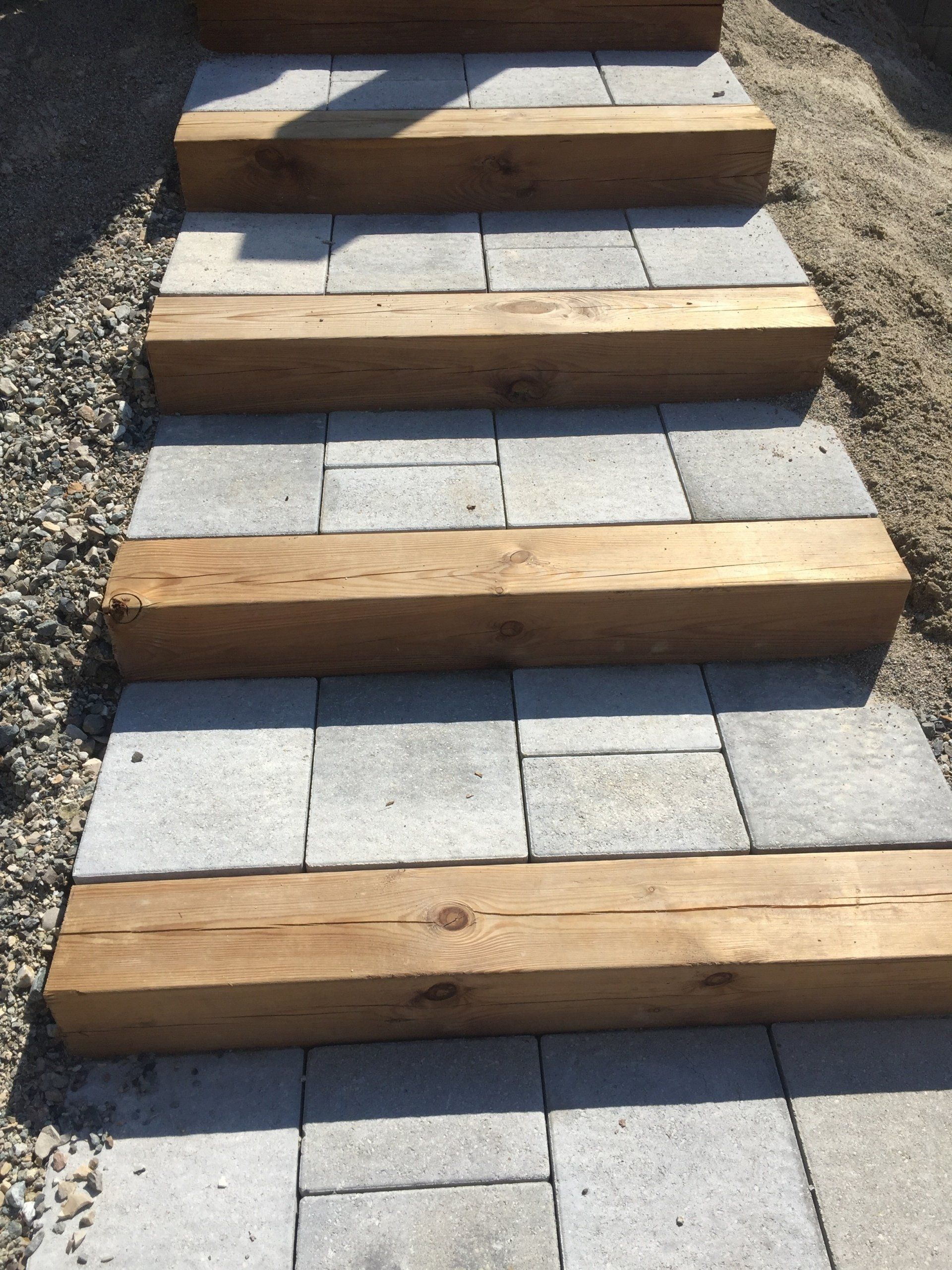 Gros plan sur de petits escaliers extérieurs en pierre grise et en bois