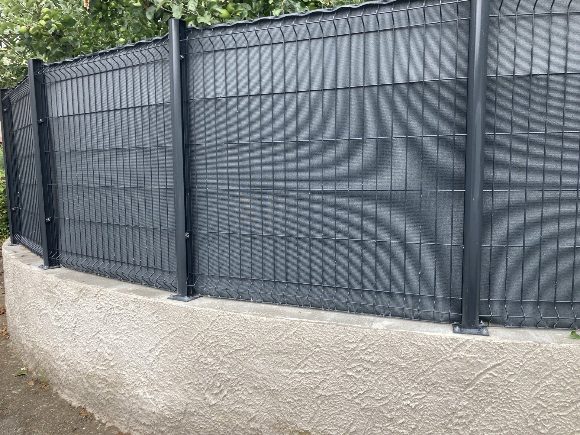 Clôture fixe noire complètement couverte du côté extérieur
