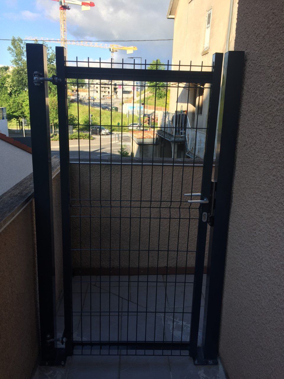 Portillon noir qui permet la vue du voisinage