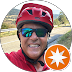 Un hombre que lleva un casco rojo y gafas de sol está sonriendo.