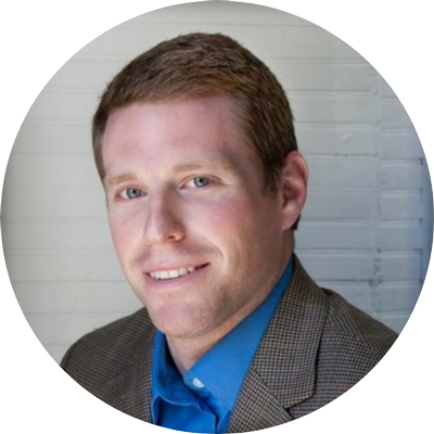 A man in a suit and blue shirt smiles for the camera