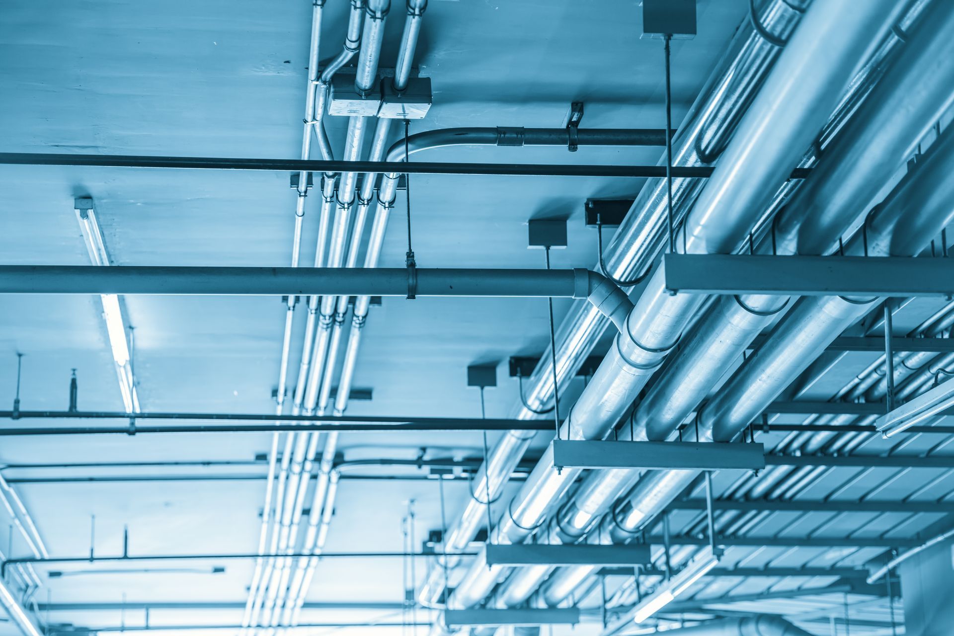 Conduits de plomberie au plafond d'un bâtiment.