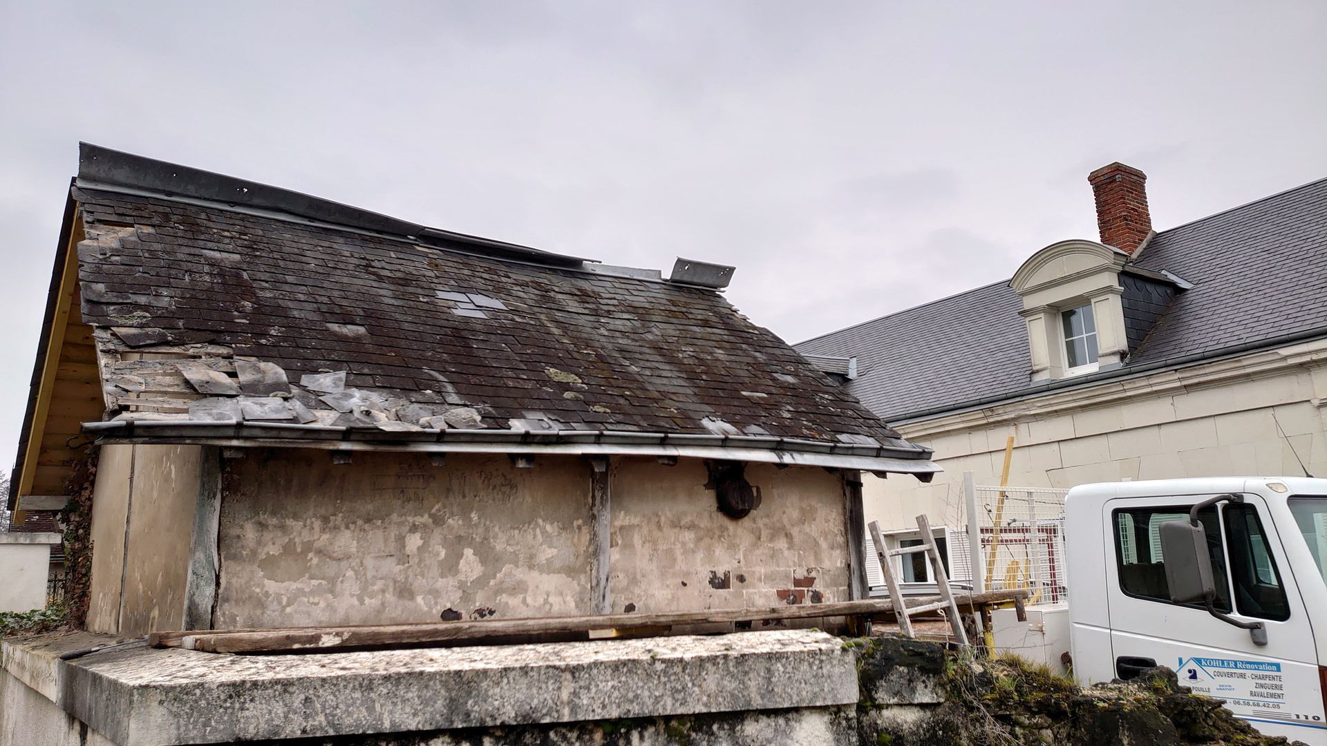 Toiture endommagée sur un petit bâtiment.