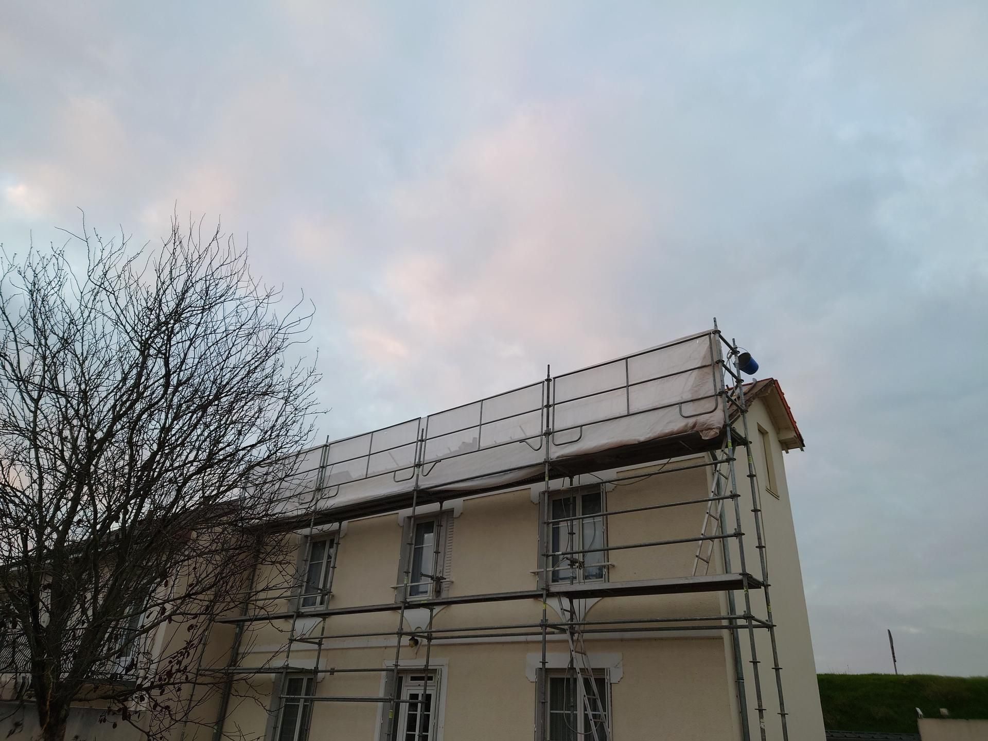 Toiture d'un bâtiment en cours de rénovation avec échafaudages.