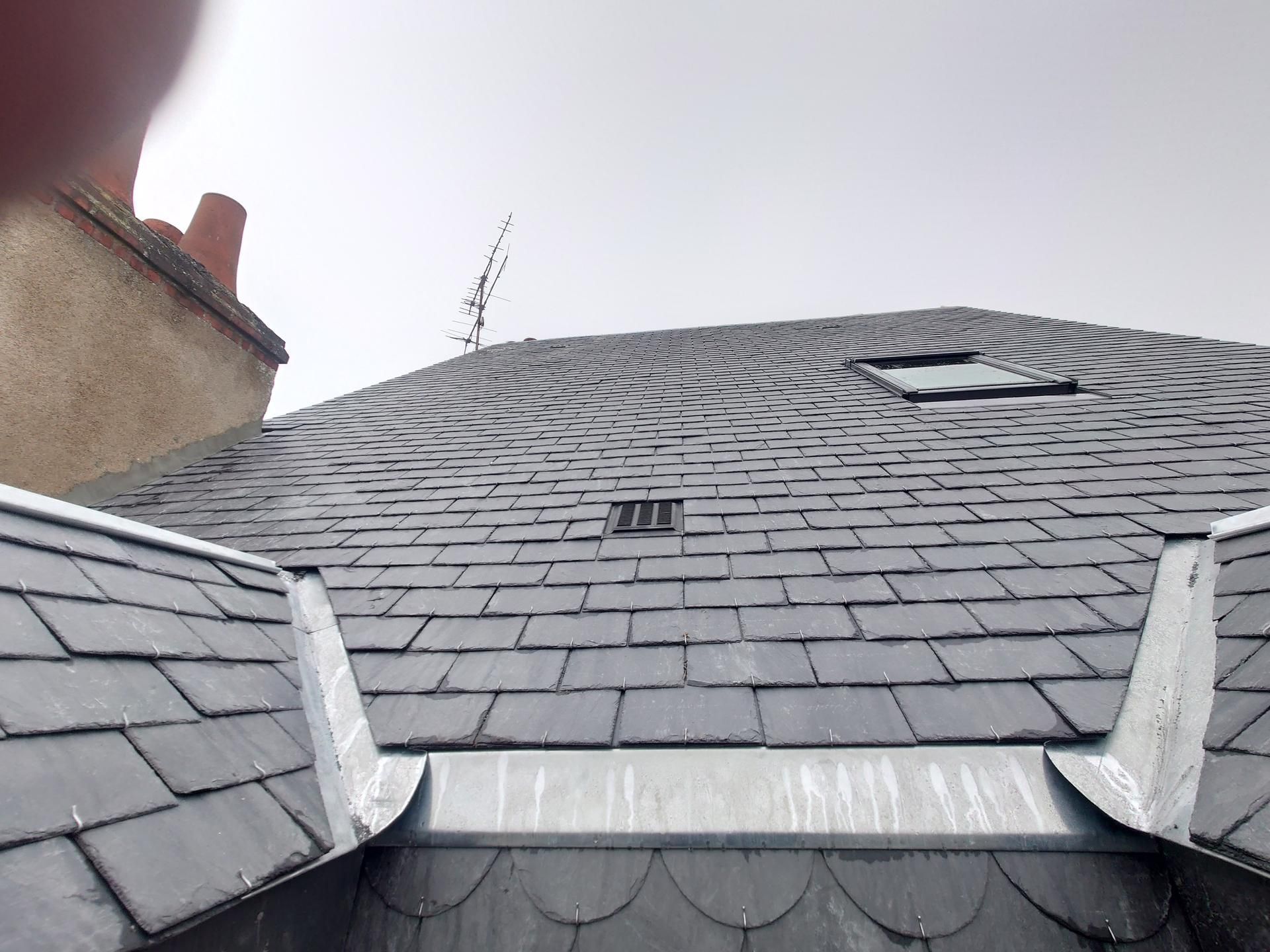 Toit en ardoise avec solins métalliques.