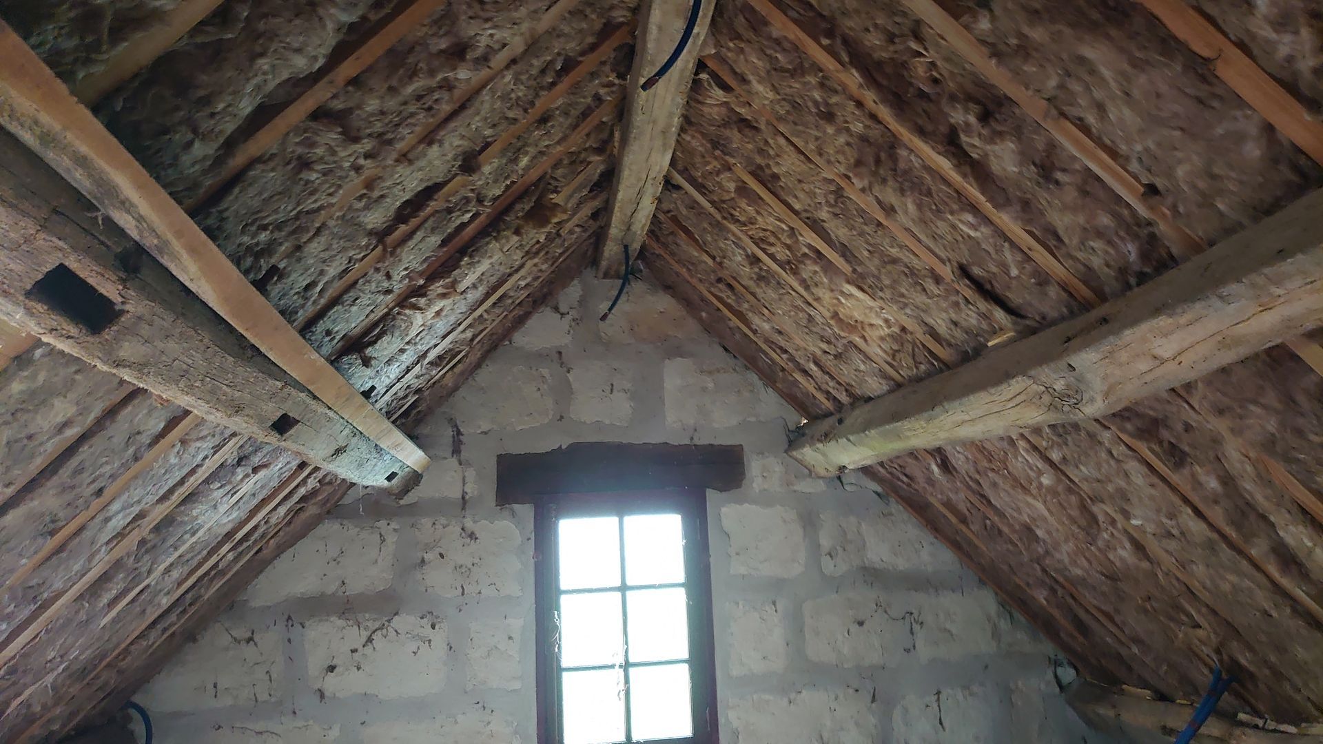 Isolation des combles entre les poutres en bois.