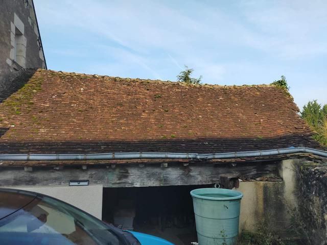 Toit vétuste en tuiles sur un bâtiment.