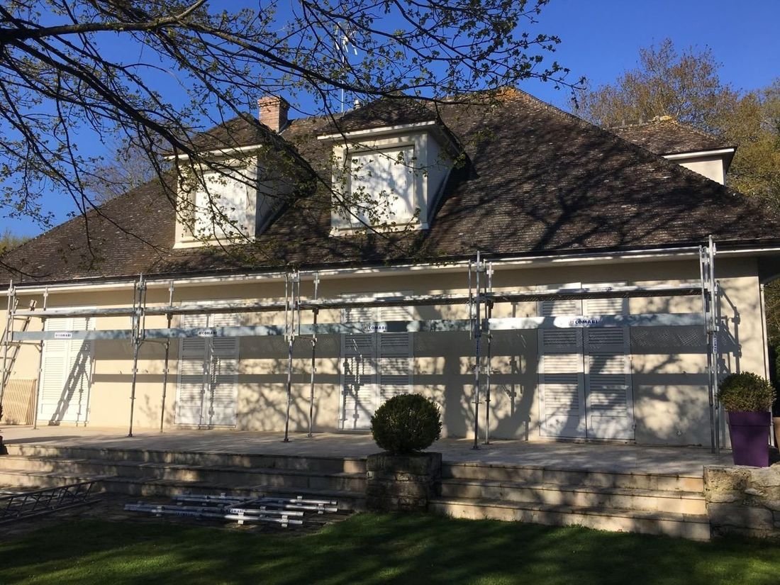 Extérieur d'une maison avec échafaudages pour rénovation. 