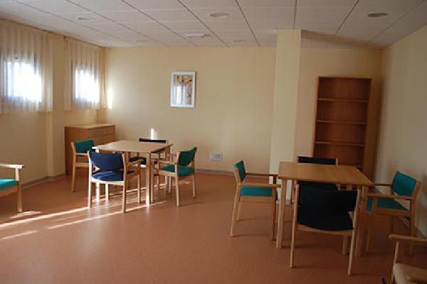 Una habitación con mesas y sillas y un cuadro en la pared.