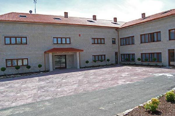 Un edificio grande con muchas ventanas y un techo rojo.