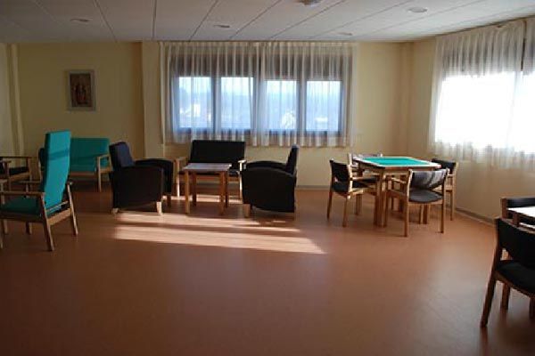 Una habitación con mesas y sillas y muchas ventanas.