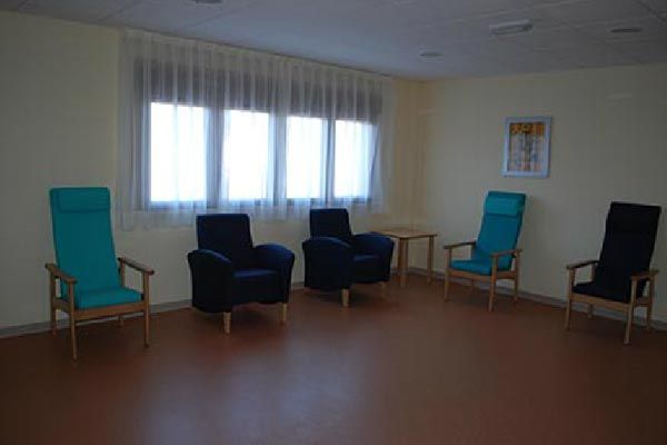 Una habitación con muchas sillas y una ventana.