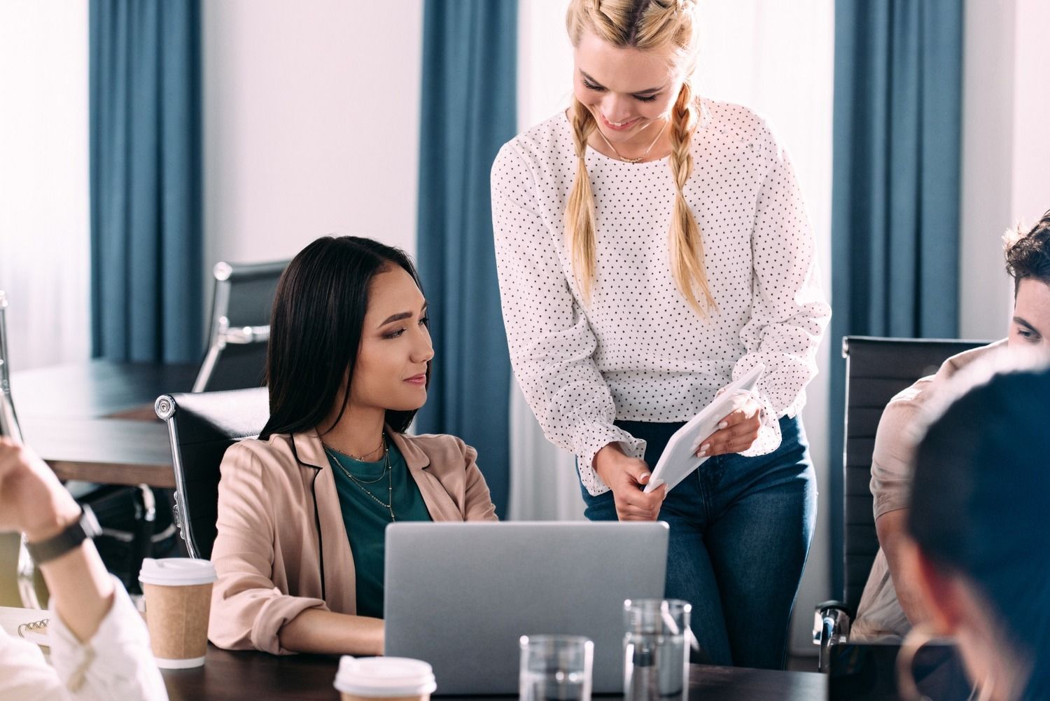 Un grupo de personas está sentado en una mesa con una computadora portátil.