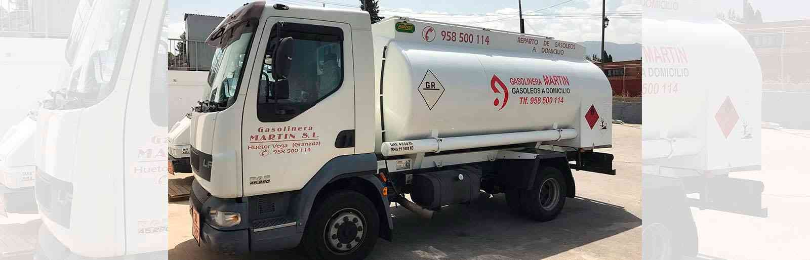 Un camión cisterna blanco está estacionado en un estacionamiento.