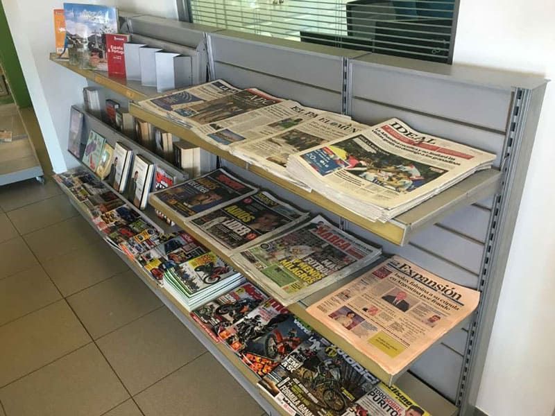 Una fila de estantes llenos de periódicos y revistas.