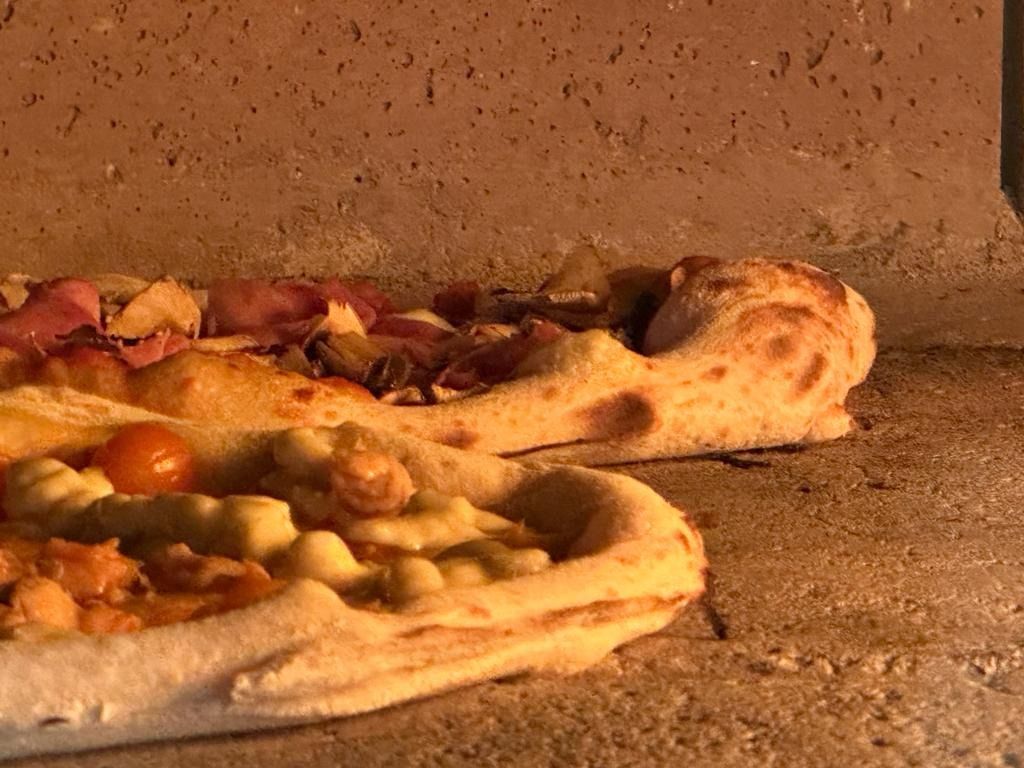 Se están cocinando dos pizzas en un horno de pizza.