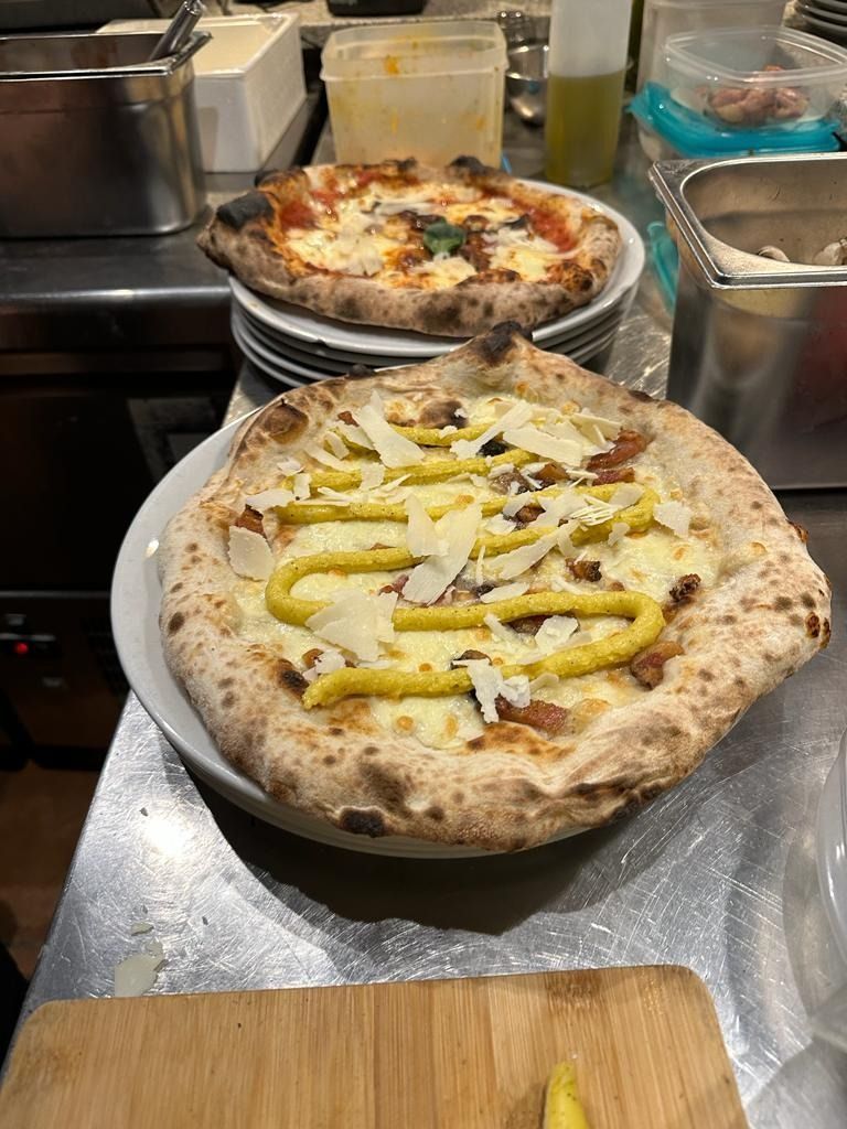 Una pizza está colocada en un plato sobre un mostrador.