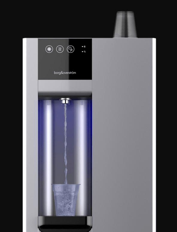 Dispensador de agua plata con chorro de agua iluminado que llena un vaso. En la parte superior hay un dispensador de vasos.