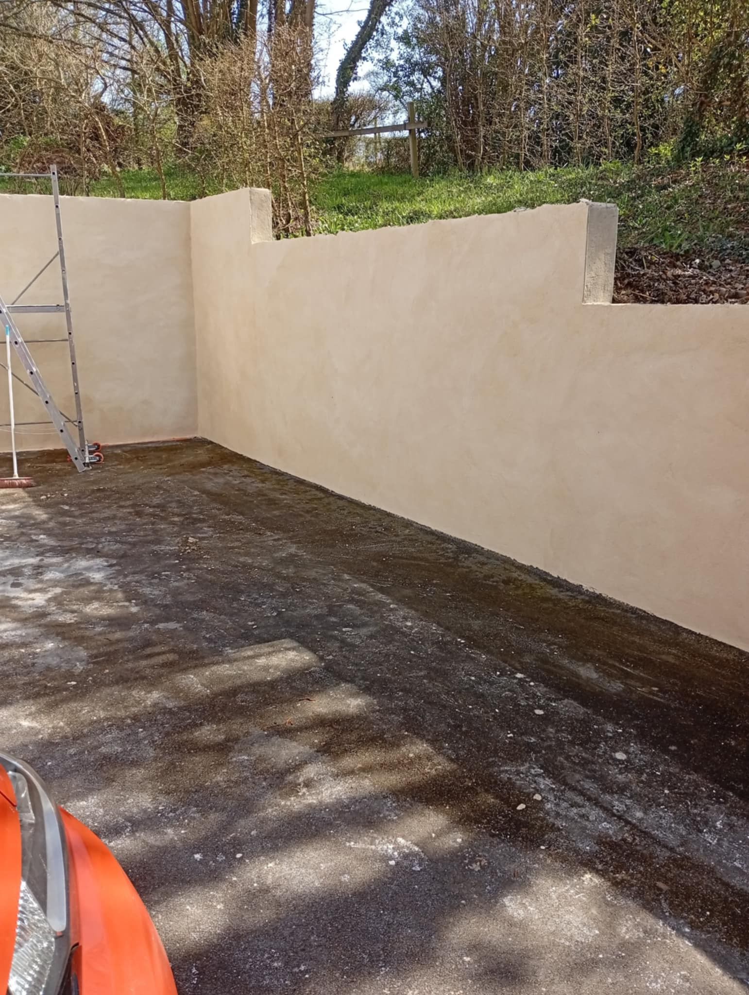 Vue extérieure d'un mur et vue partielle d'une échelle.