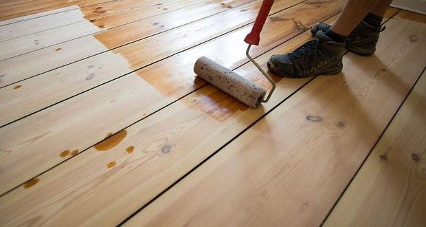 Photo d'un parqueteur qui vitrifie un parquet