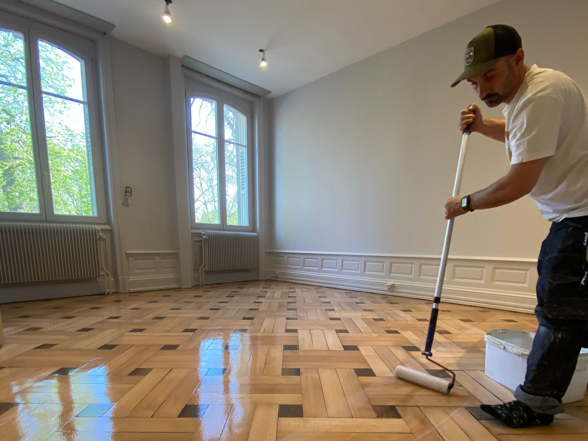 Photo de M. Garcia avec un rouleau de vernis à la main