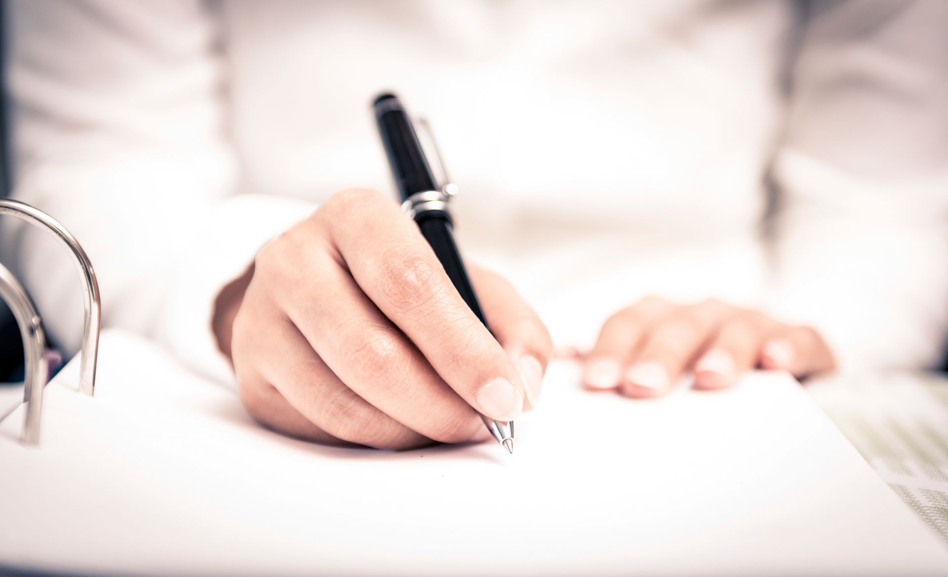 Photo de la main d'une femme avec un stylo qui écrit