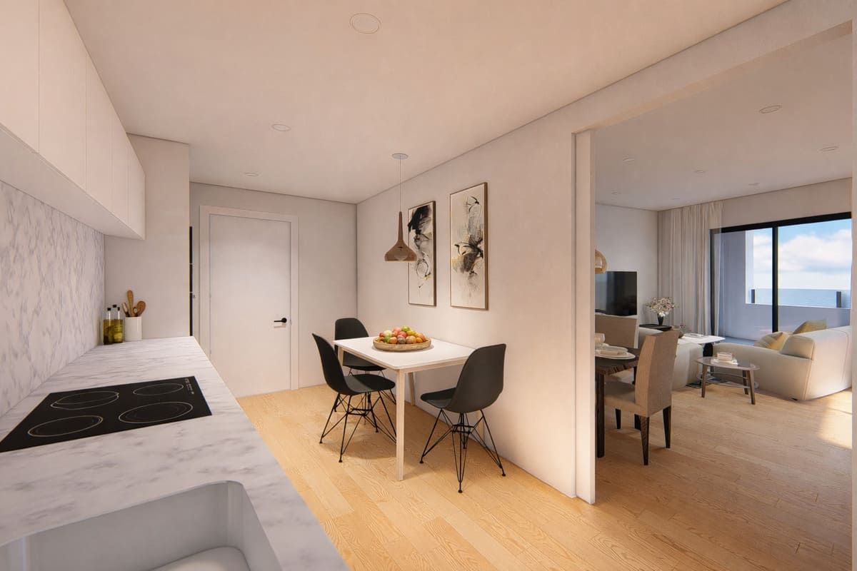 Vista interior de un apartamento: cocina y comedor con decoración moderna, que conduce a una sala de estar con vista al mar.