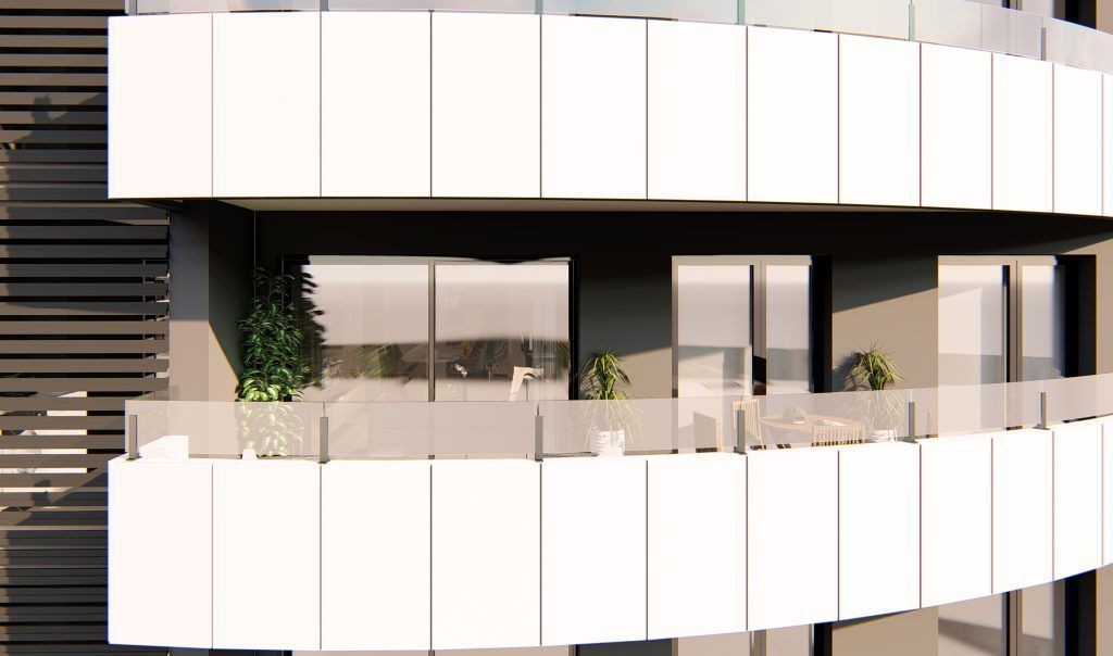 Edificio moderno con balcones curvos y barandillas de cristal, con plantas y muebles de exterior.