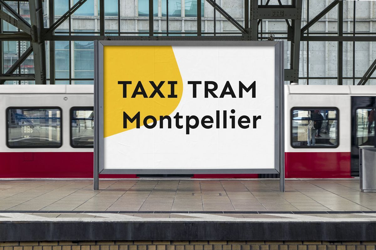 Pancarte publicitaire dans une gare affichant Taxi Tram Montpellier sur fond blanc et forme jaune