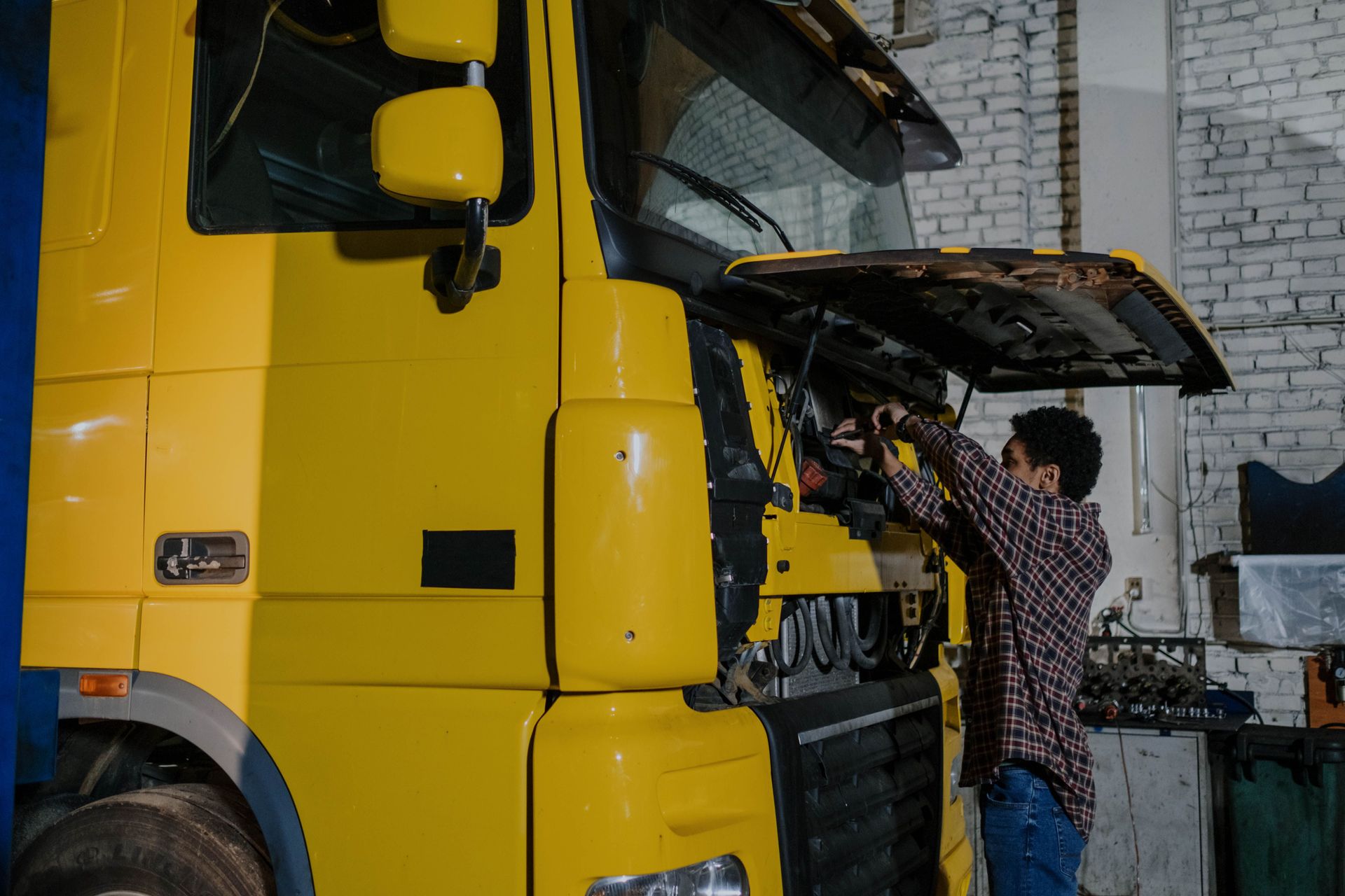 Technicien intervenant sur le moteur d'un camion pour un rétrofit
