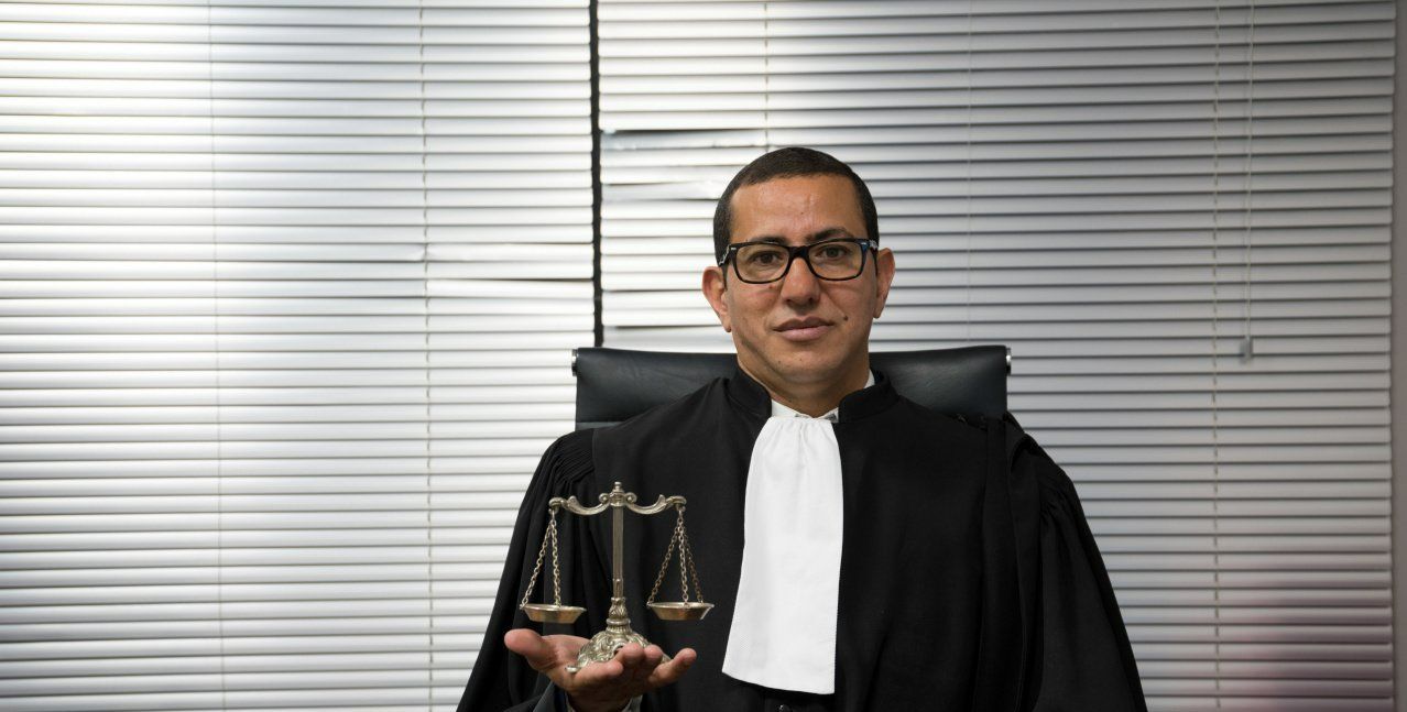 Maître Zouaoui avec une robe d'avocat et des lunettes noires