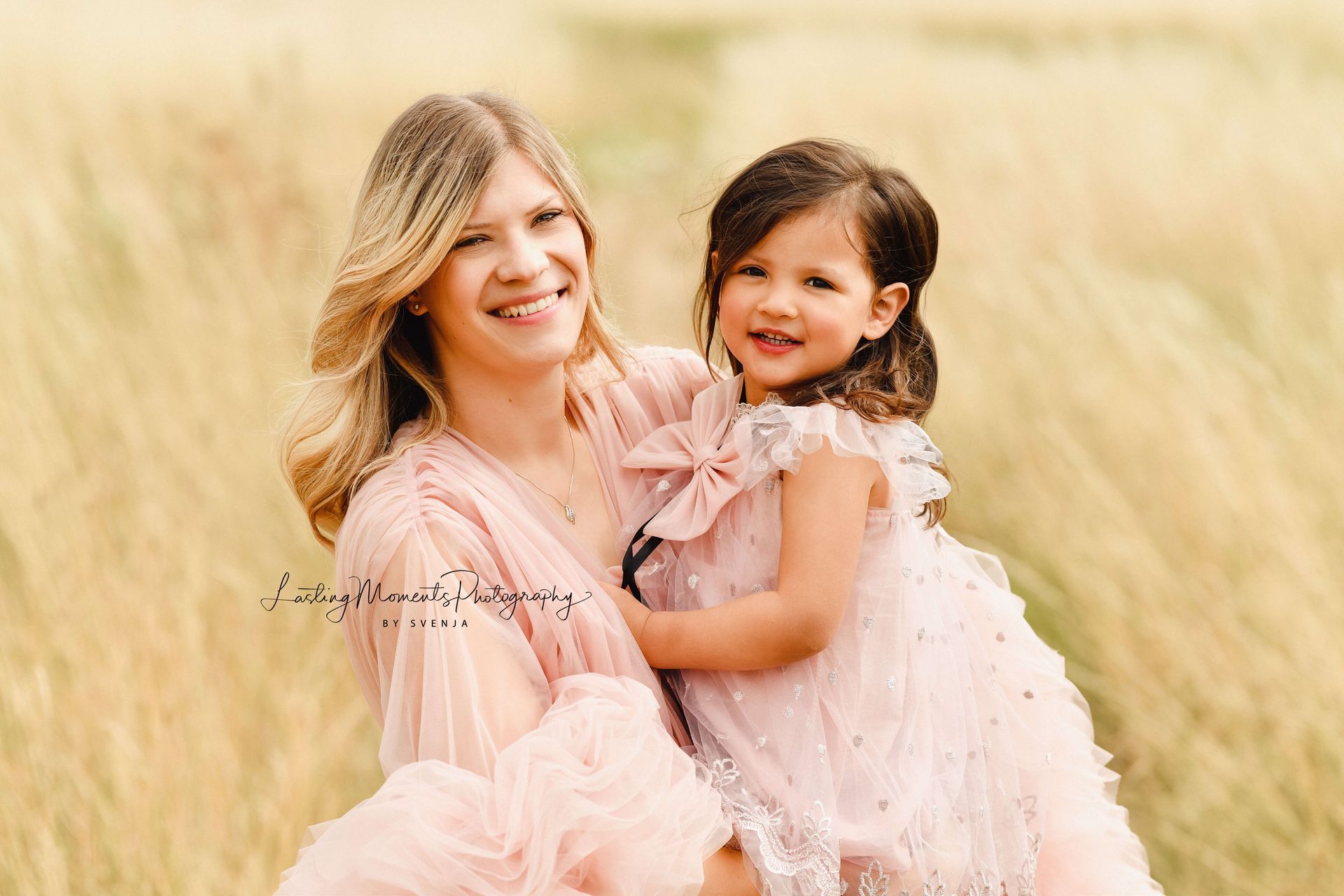 Eine Frau hält auf einem Feld ein kleines Mädchen in ihren Armen.