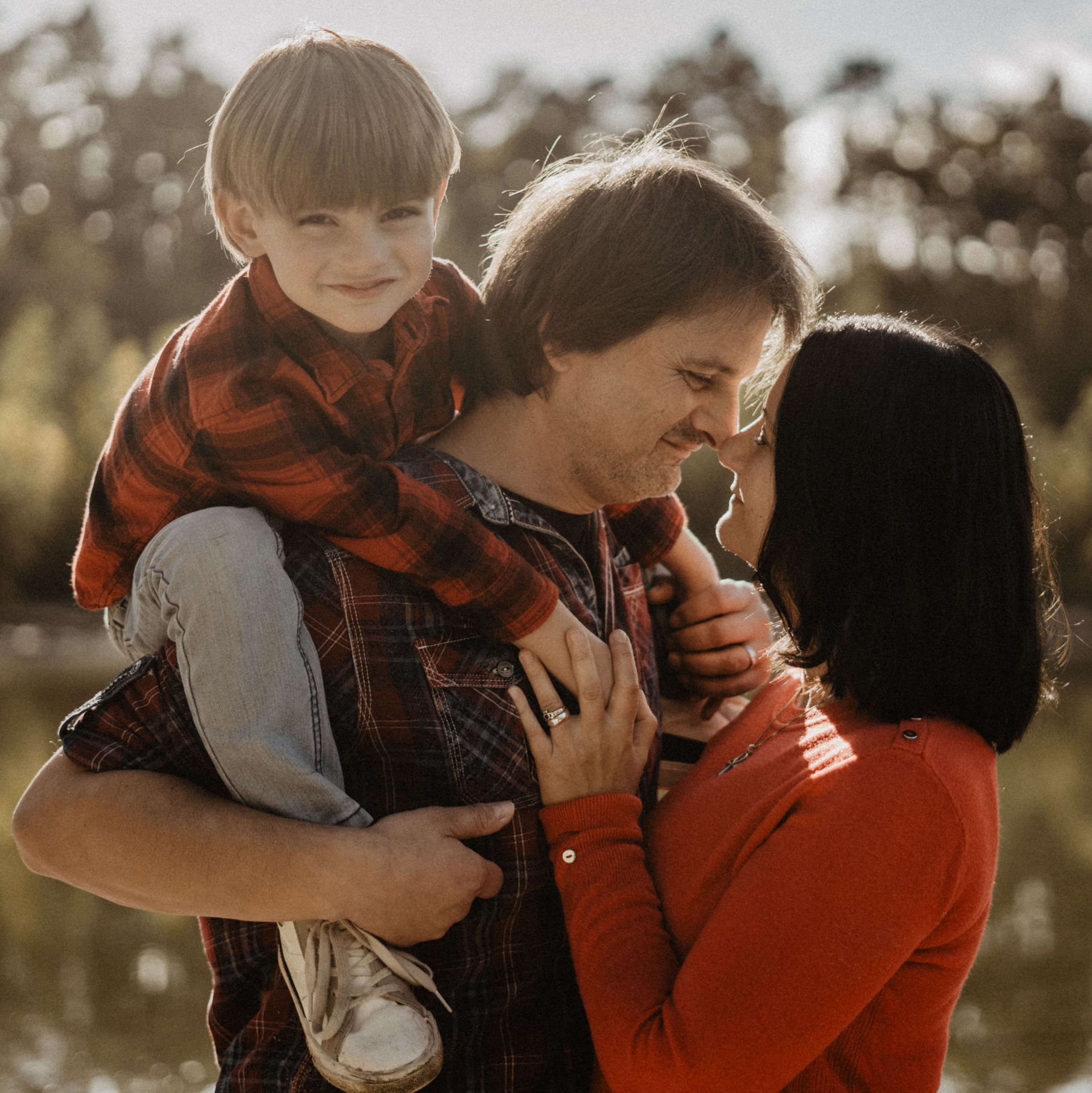 Ein Mann und eine Frau halten ein Kind auf ihren Schultern.