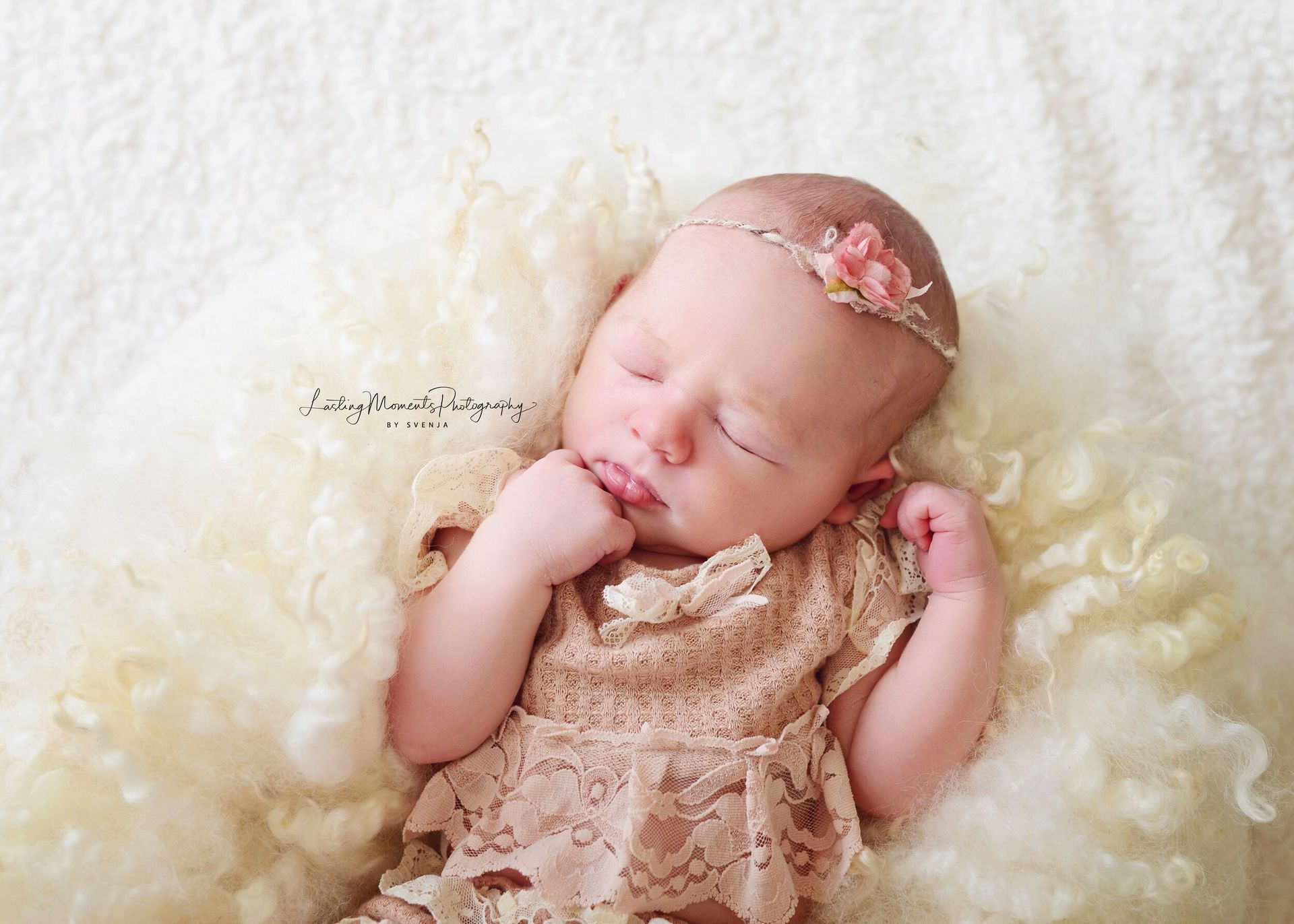 Ein neugeborenes Mädchen schläft auf einer weißen Decke.