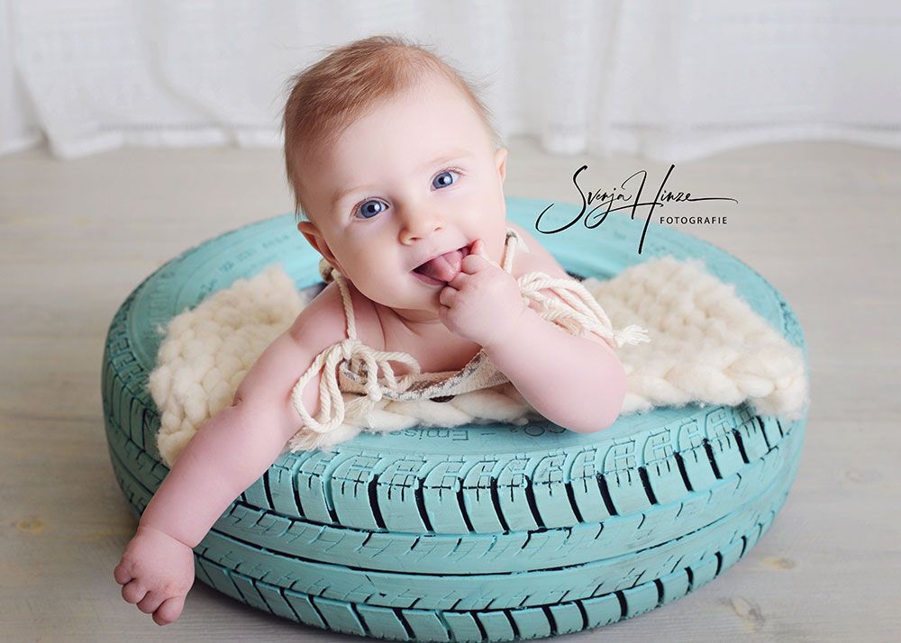 Ein Baby liegt auf einem blauen Reifen.