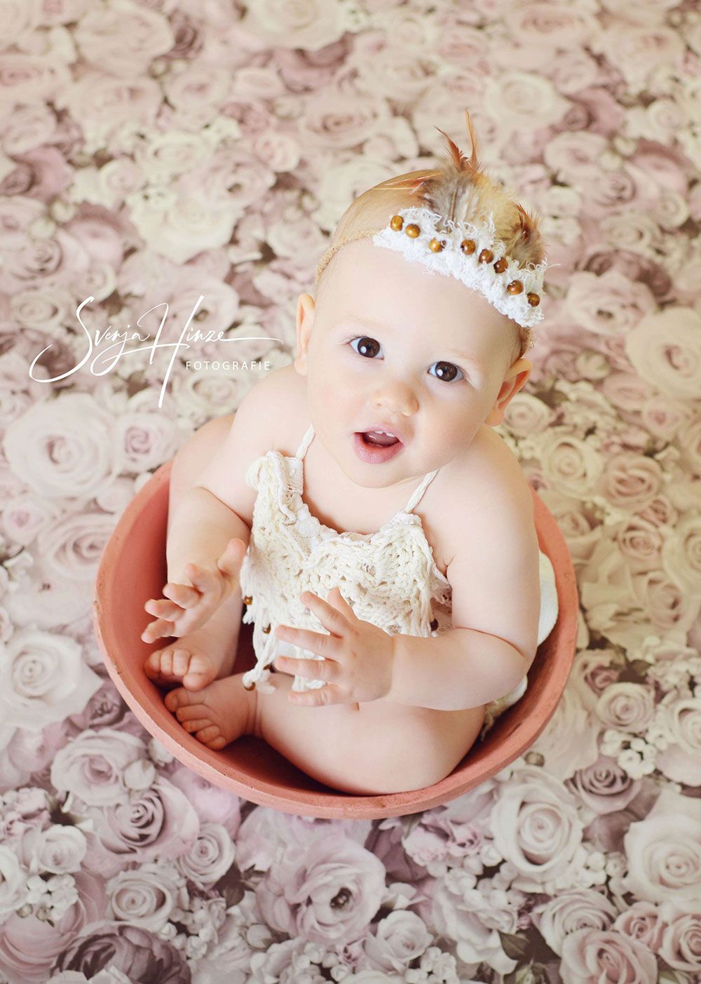 Ein Baby mit einer Krone auf dem Kopf sitzt in einer Schüssel.