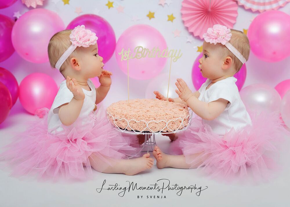 Zwei kleine Mädchen sitzen nebeneinander und essen einen Kuchen.